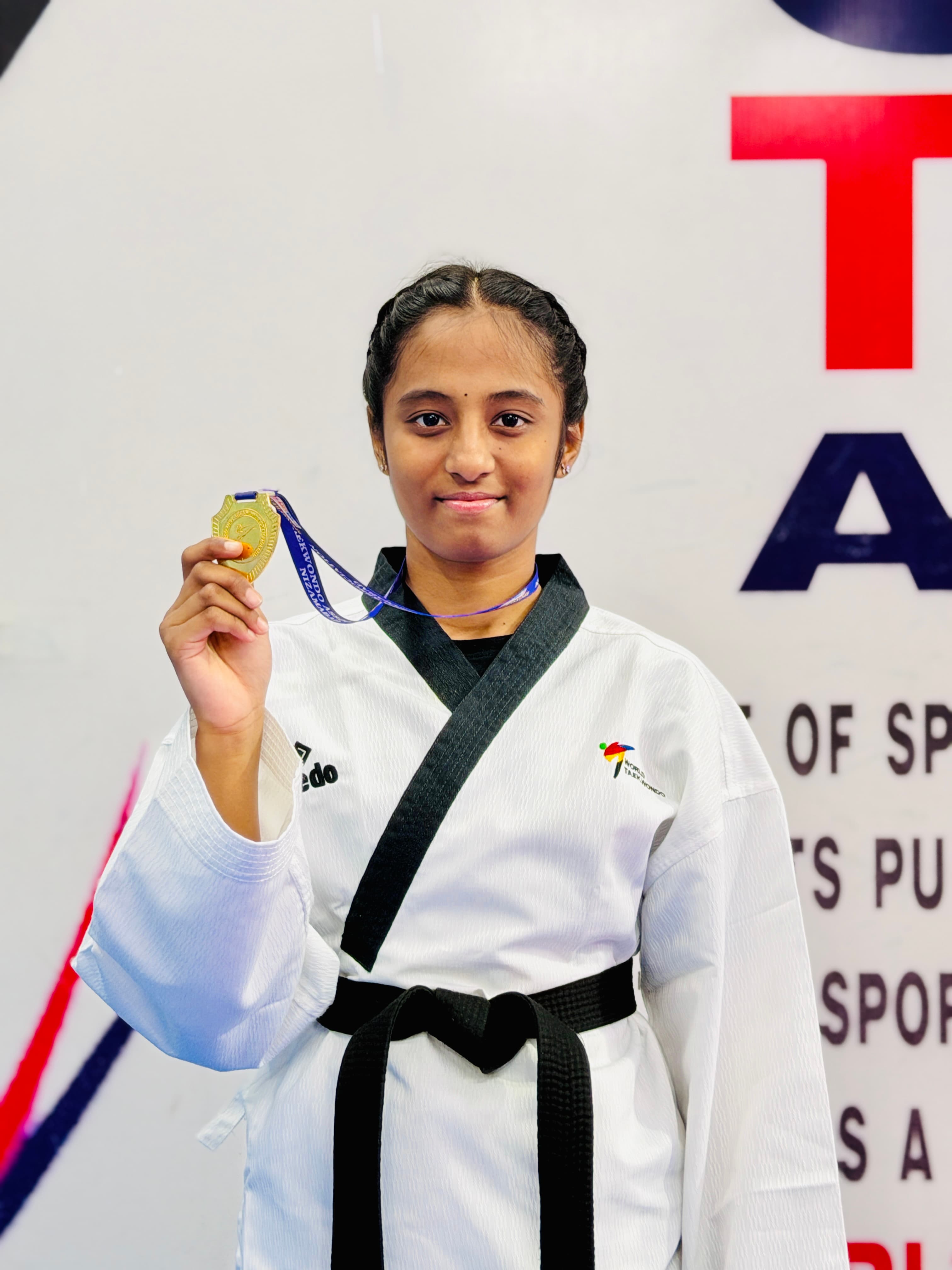 Student athlete with a gold medal at a Telangana Taekwondo championship