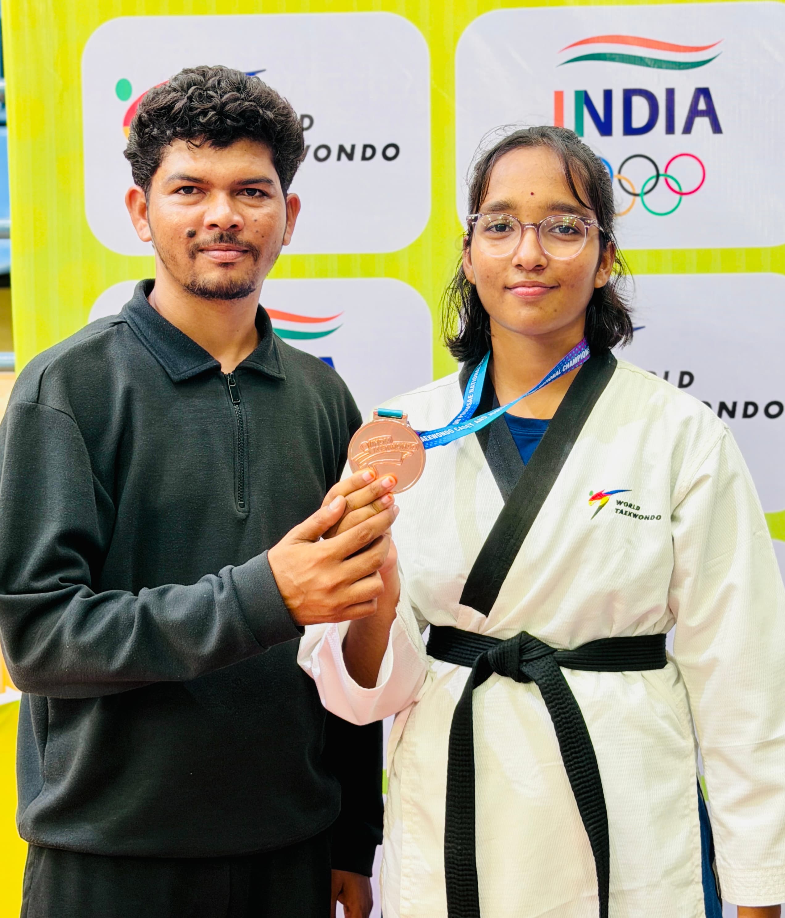 Student with a bronze medal alongside coaches