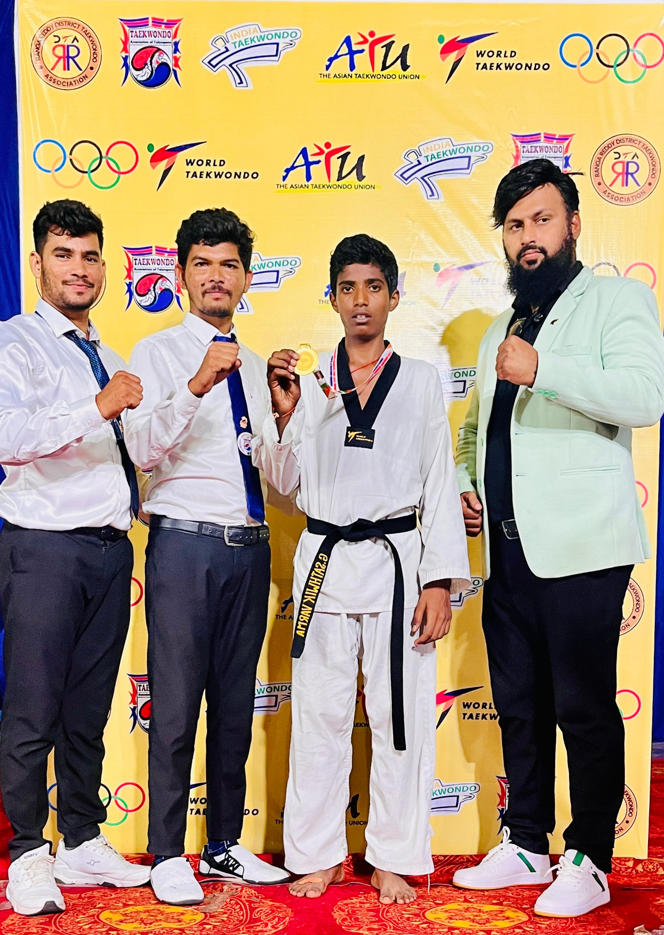 Students with a gold medal at a Taekwondo tournament